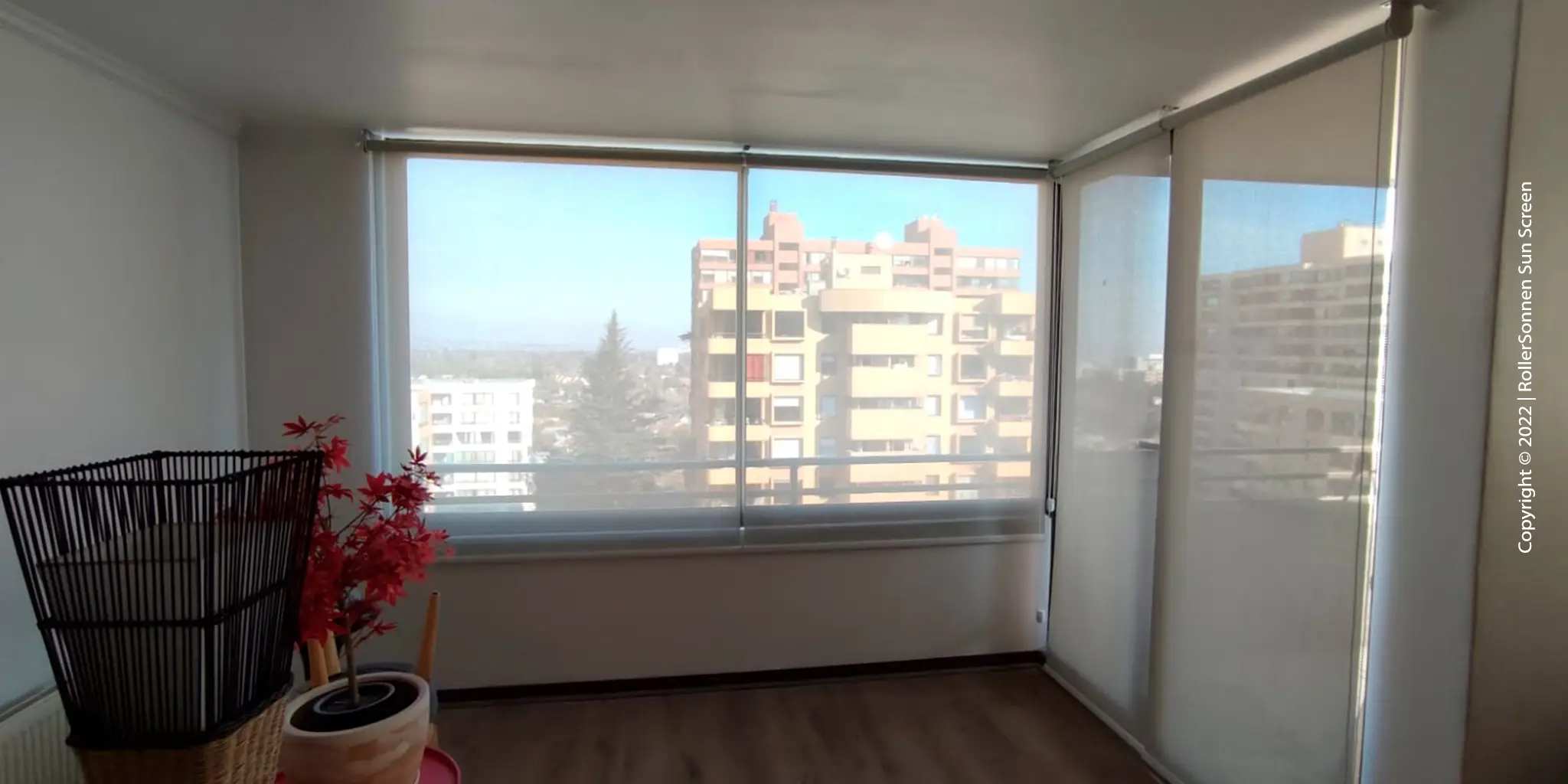 Sala de estar con una elegante cortina roller Sun Screen que filtra suavemente la luz solar.